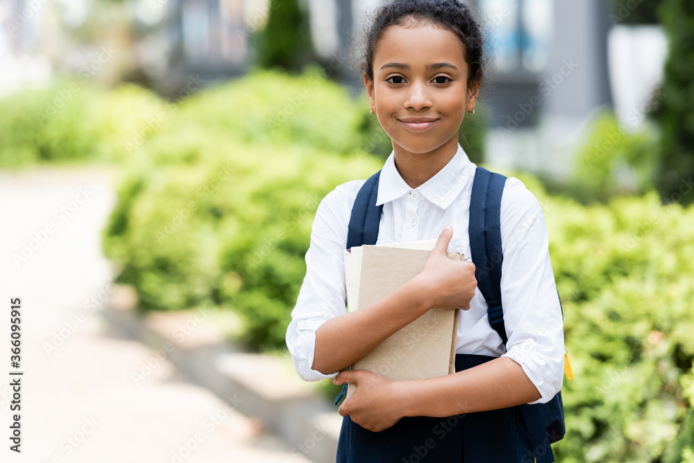smiling african american schoolgirl with book outdoors smiling african american schoolgirl with book outdoors