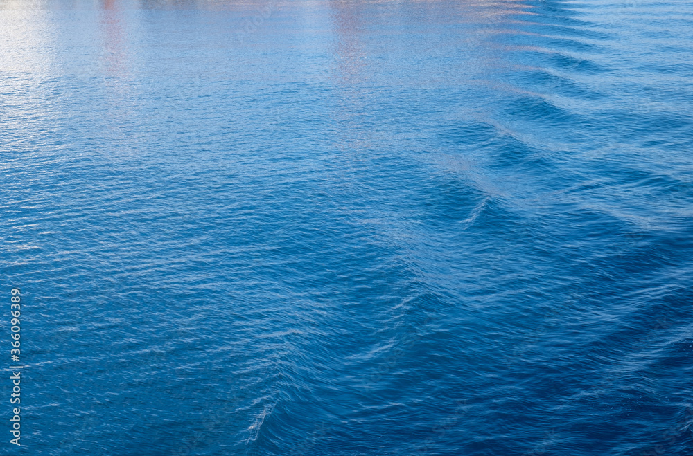 Sea water surface background. Calm blue water rippled with reflections