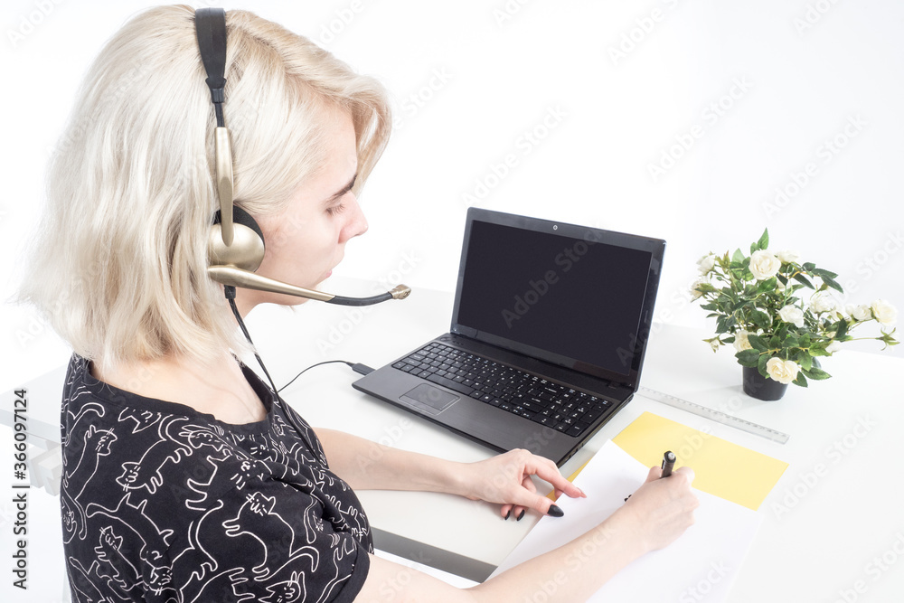 Girl works as agent in a call center. Sales agent near computer. Call center employee sits with his back to camera. Woman laptop table is writing something. Young operator woman agent with headsets Girl works as agent in a call center. Sales agent near computer. Call center employee sits with his back to camera. Woman laptop table is writing something. Young operator woman agent with headsets