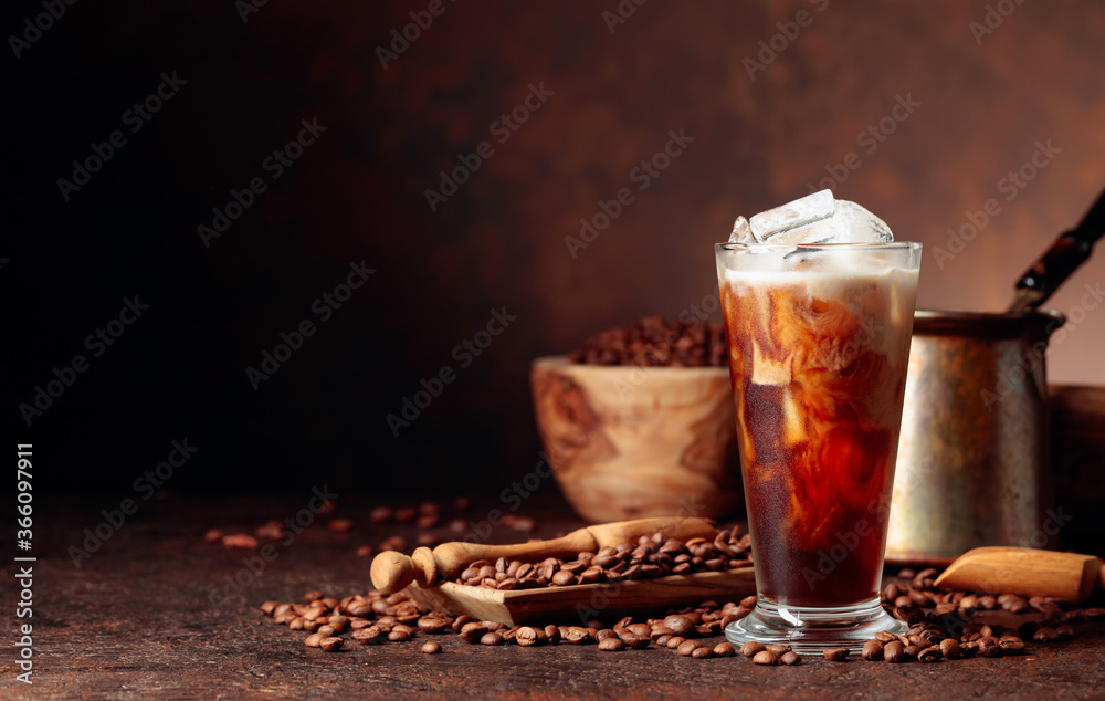 Ice coffee with cream being poured into it showing the texture and refreshing look of the drink. Ice coffee with cream being poured into it showing the texture and refreshing look of the drink.