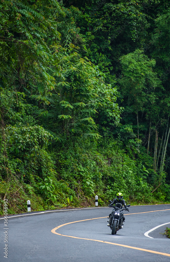 woamn riding her motorcycle on empty highway in Thailand woamn riding her motorcycle on empty highway in Thailand