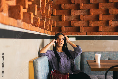 woman talking on the phone while relaxing in a coffee shop photo