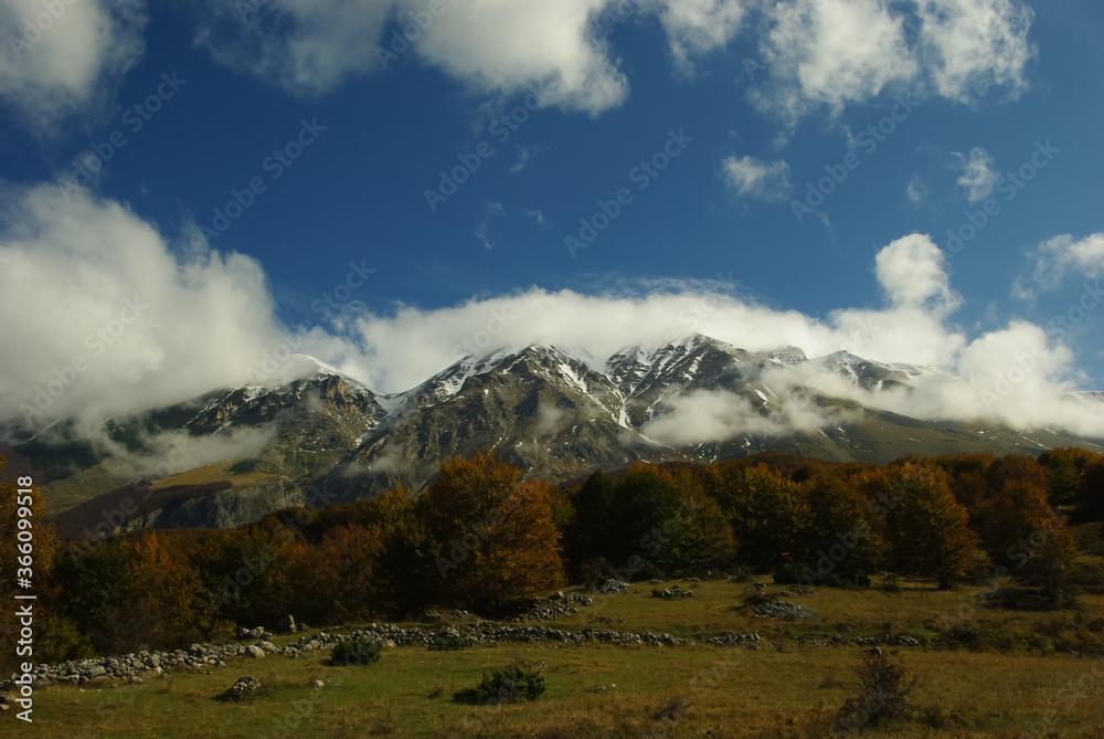 View of the Majella mountains in Abruzzo, in the foreground a beech forest that begins to be tinged with the first autumn colors. View of the Majella mountains in Abruzzo, in the foreground a beech forest that begins to be tinged with the first autumn colors.