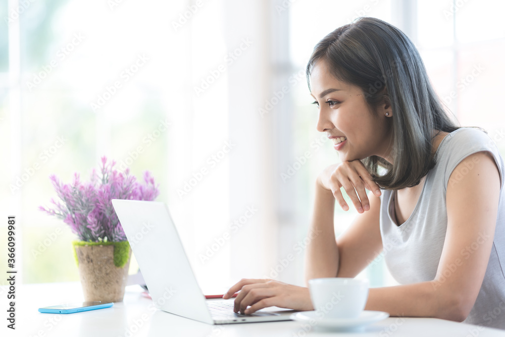 Asian young women using labtop for working at home, living and work at home Asian young women using labtop for working at home, living and work at home