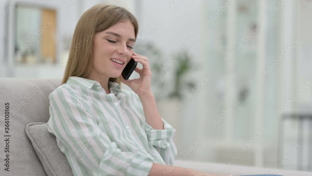 Cheerful Young Woman Talking on Smartphone at Home Cheerful Young Woman Talking on Smartphone at Home