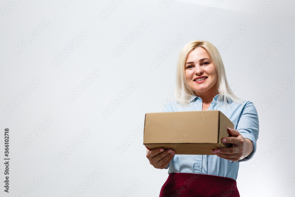 A young beautiful caucasian woman holding a box in her hands. A young beautiful caucasian woman holding a box in her hands.