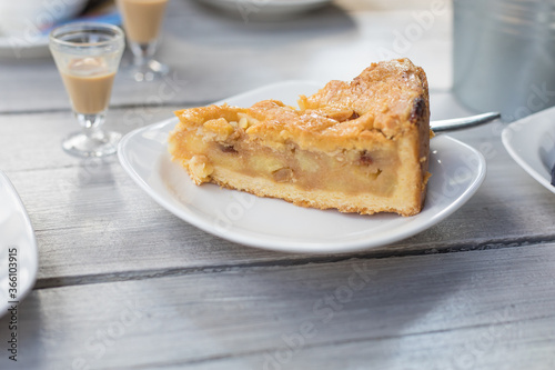 Apple pie, coffee and little glasses of liqueur, outdoor on a summer day