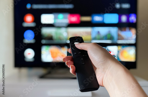 Hand holds remote control from smart TV