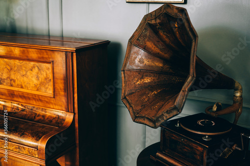 Tableau sur toile Retro old gramophone radio with horn speaker stands with old piano, Music and nostalgia concept
