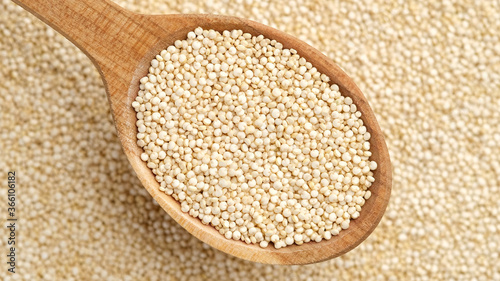 quinoa seeds in wooden spoon and on background. top view