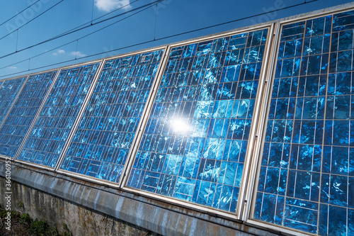 Mosaic Solar panels with sun rays and cloud reflections