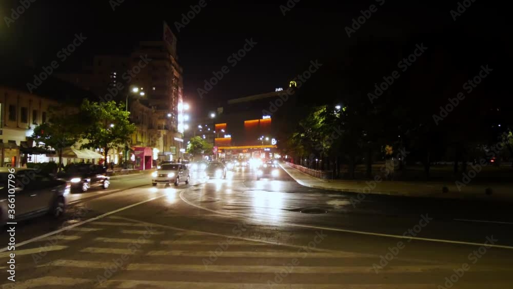 Busy street at night in european country, police car crossing at speed. Busy street at night in european country, police car crossing at speed.