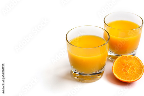 Two glasses of orange juice on a white background