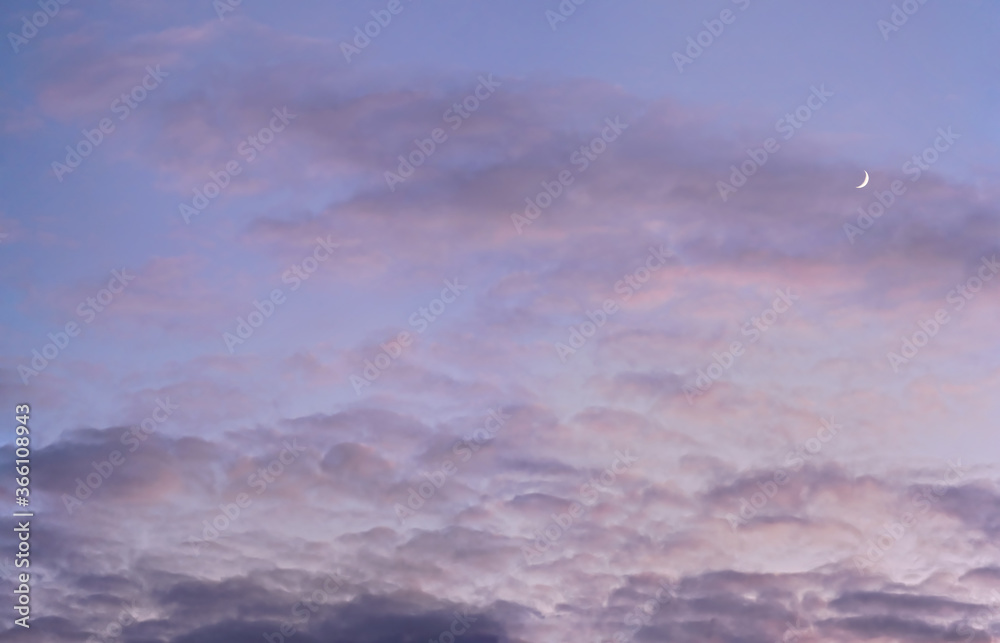 Evening purple sky with some barely visible clouds, moon crescent in right side - blue hour background Evening purple sky with some barely visible clouds, moon crescent in right side - blue hour background