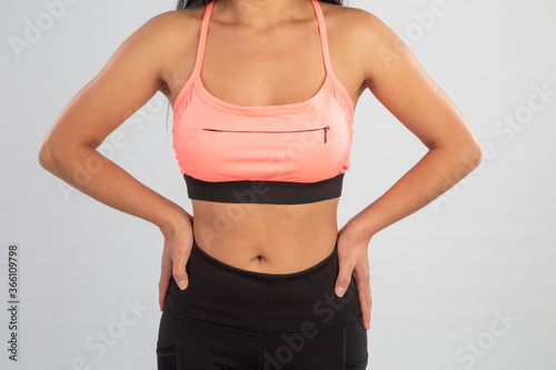 closeup of the body of an athletic woman with sportswear and hands on the waist
