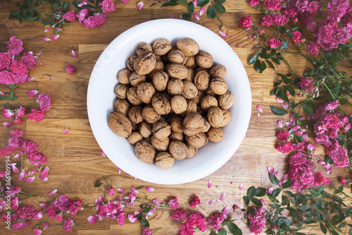 Walnut kernels and whole walnuts on rustic old wooden table