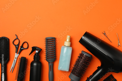 Composition with hairdresser accessories on orange background, space for text