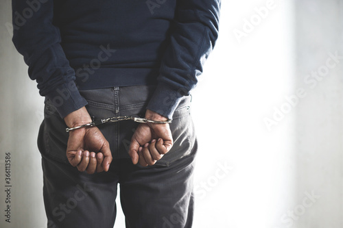 Fotografía Prisoner male criminal standing in handcuffs with hands behind back