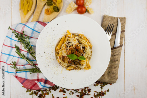 bolognese pasta with cheese on wooden background