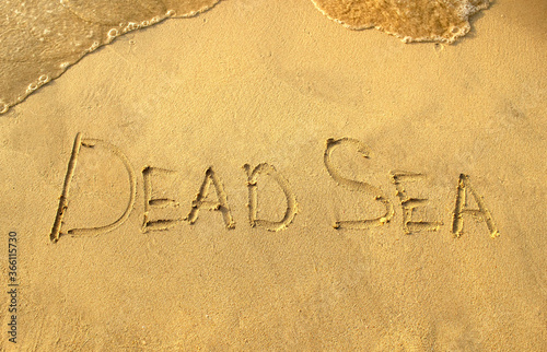 Dead Sea words on beach sand. Dead Sea phrase is written on a sand.  photo