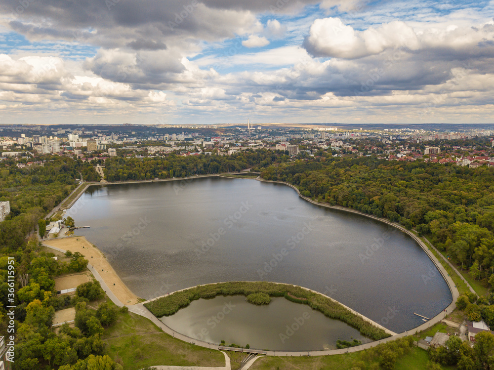 Obraz premium Aerial view of a lake in a park with autumn trees. Kishinev, Moldova. Epic aerial flight over water. Colorful autumn trees in the daytime.