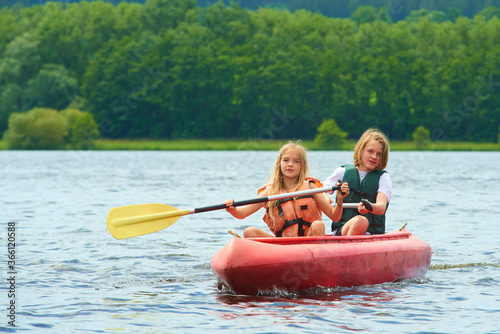 Children siblings girl and boy (brother and sister) kayaking on vacation
