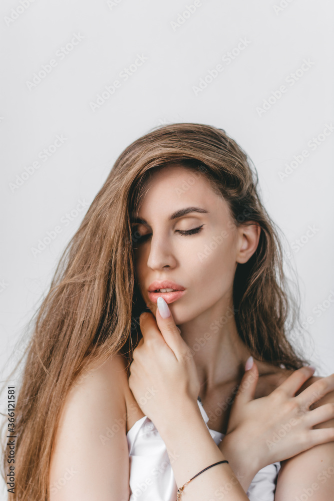 Close-up portrait of a sexy caucasian girl with closed eyes with long brown hair. Healthy hair and beautiful professional makeup. Hair care, skin care concept Close-up portrait of a sexy caucasian girl with closed eyes with long brown hair. Healthy hair and beautiful professional makeup. Hair care, skin care concept