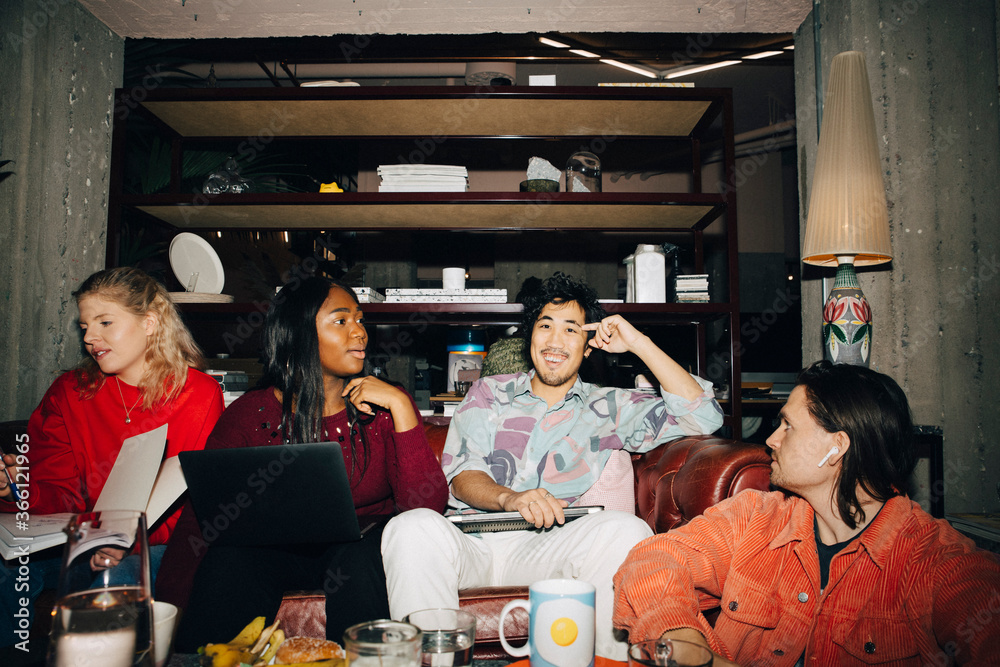 Male and female entrepreneurs discussing while working in creative office