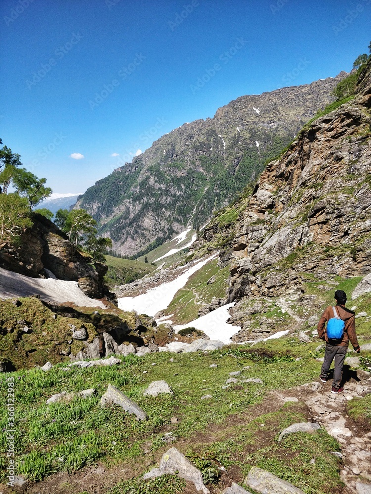 Manali, India - June 15th 2019: A Solo hiker climbing down a narrow snowy/Glacial valley in Indian Himalayan Mountain.