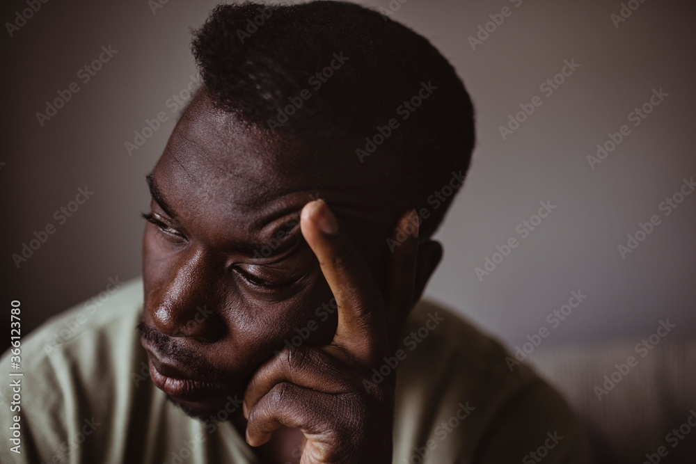 Close-up of sad man holding head in hand while looking away Close-up of sad man holding head in hand while looking away