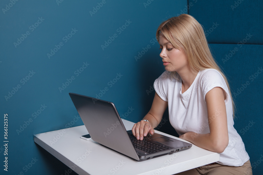 Attractive woman using her laptop, sitting in a modern workspace office Attractive woman using her laptop, sitting in a modern workspace office
