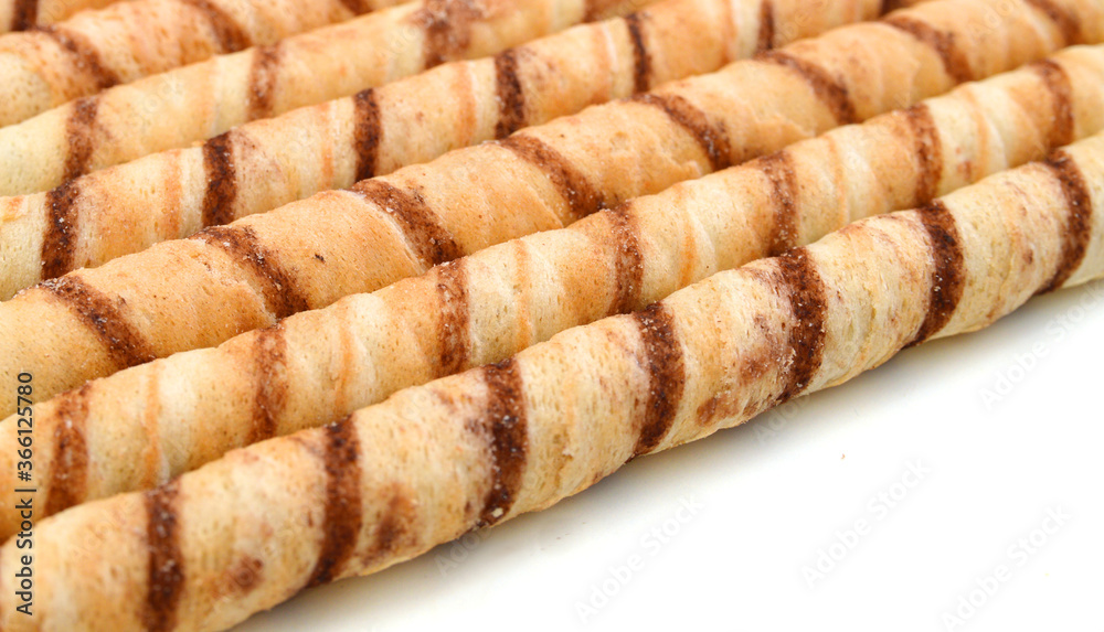 Heap of striped wafer tubules with the chocolate creamon background Heap of striped wafer tubules with the chocolate creamon background