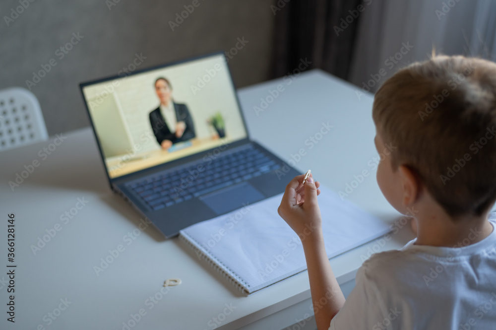A boy learns the alphabet with a laptop teacher. Distance learning by video conference. Remote preschool education. A boy learns the alphabet with a laptop teacher. Distance learning by video conference. Remote preschool education.