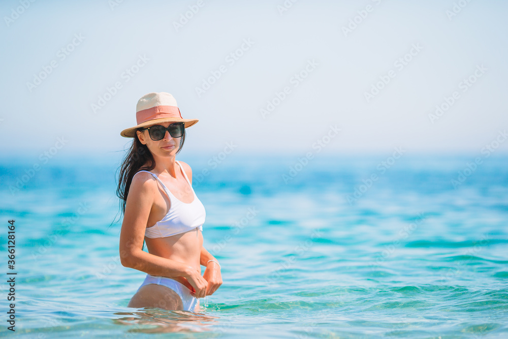 Young beautiful woman having fun on tropical seashore. Happy girl background the blue sky and turquoise water in the sea Young beautiful woman having fun on tropical seashore. Happy girl background the blue sky and turquoise water in the sea