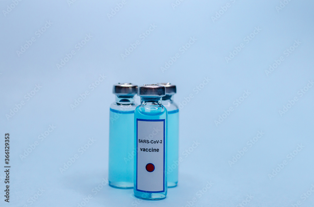 Coronavirus vaccine in glass vials on a blue background. Coronavirus vaccine in glass vials on a blue background.
