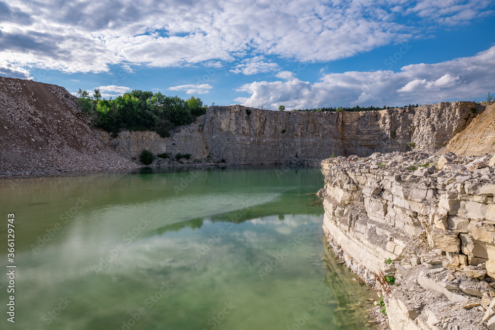 Green stone quarry lake on summer day