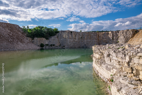 Green stone quarry lake on summer day