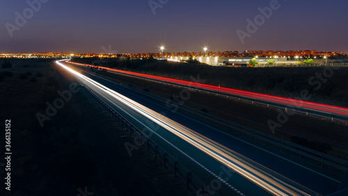 Car light trails on a curved road at the blue hour