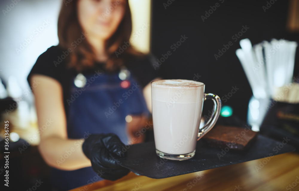 Barista wearing medical latex black gloves, making pink matcha latte with milk. Bartender preparing tasty drink and brownie cake.Blurred image,selective focus Barista wearing medical latex black gloves, making pink matcha latte with milk. Bartender preparing tasty drink and brownie cake.Blurred image,selective focus