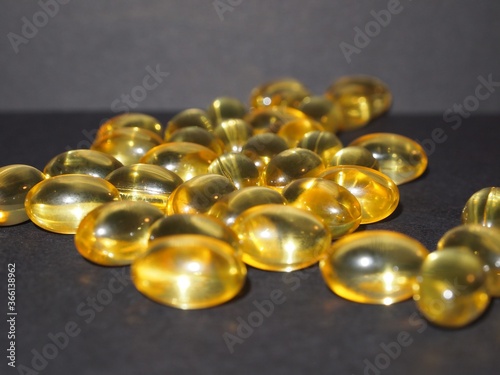 Trans-lucid cod liver oil pills under colourful light