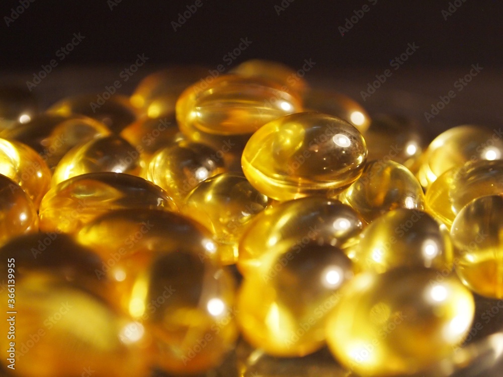 Trans-lucid cod liver oil pills under colourful light