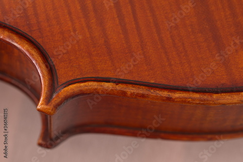 Ein Teil des Randes von einem Geigen Korpus mit den kunstvollen, Hand gemachte Details . Das Instrument liegt auf einem weißen Tuch.