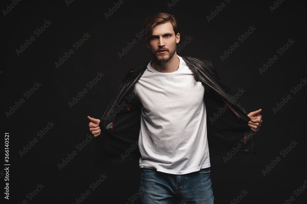 Fashion man, Handsome serious beauty male model portrait wear leather jacket, young guy over black background Fashion man, Handsome serious beauty male model portrait wear leather jacket, young guy over black background