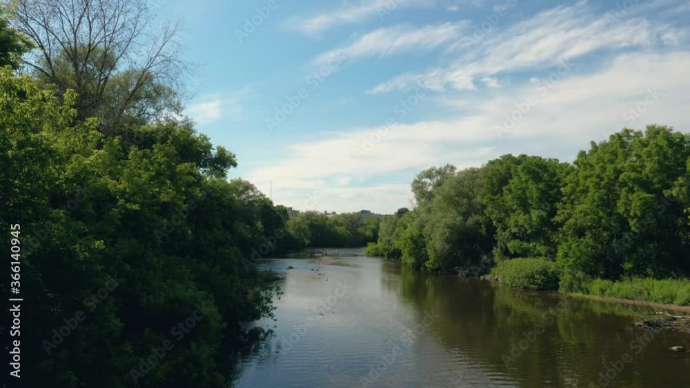 Calming River on Beautiful Summer Day - Greenery and Bright Blue Skies - Guelph Ontario Canada Calming River on Beautiful Summer Day - Greenery and Bright Blue Skies - Guelph Ontario Canada