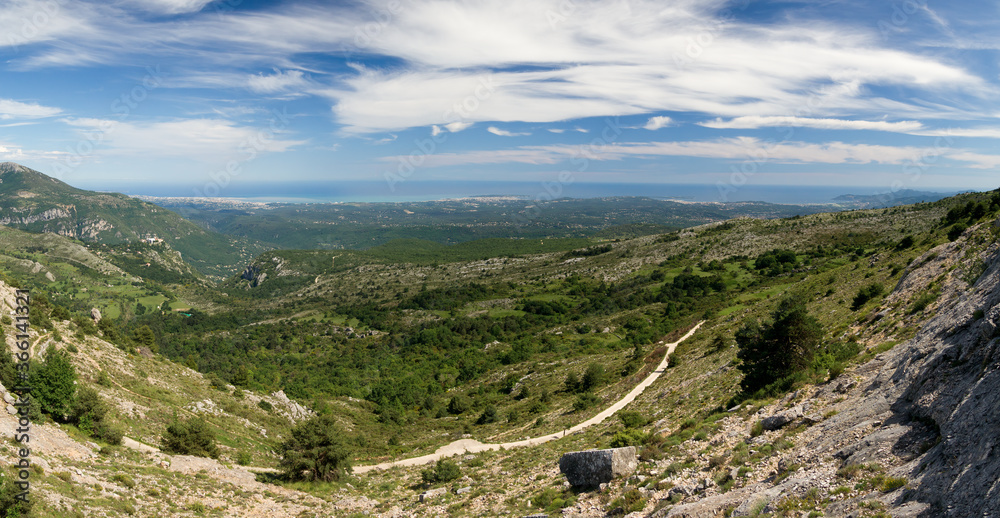Aerial landscape with mediterranean sea, forest, hills, blue sky and cloud patches. French riviera in July.