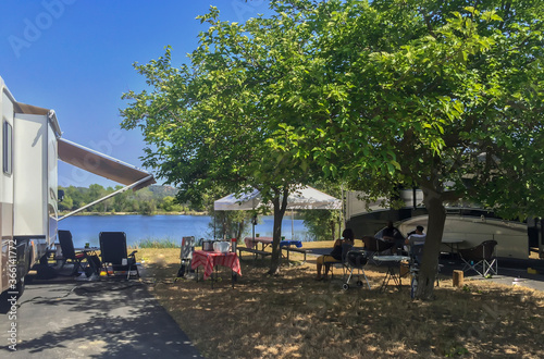 Rv camping next to a lake on a sunny summer day © Larry D Crain