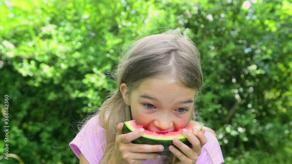 Adorable blonde child girl eats a slice of watermelon outdoors Adorable blonde child girl eats a slice of watermelon outdoors