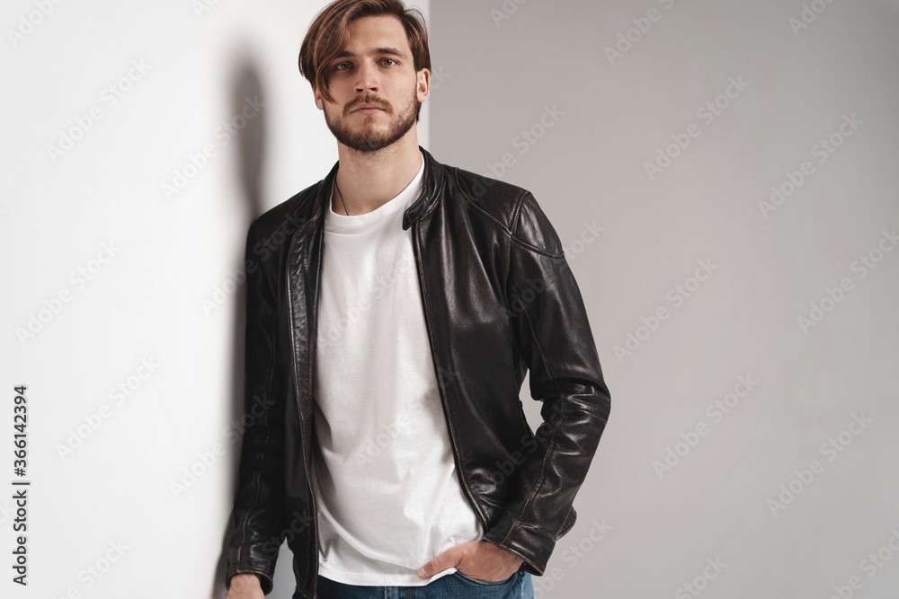 Fototapeta premium Fashion man, Handsome serious beauty male model portrait wear leather jacket, young guy over white background