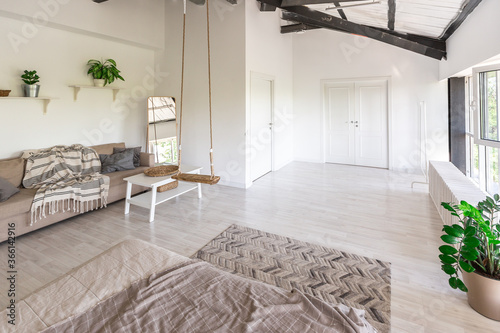 Luxury bedroom design in a rustic cottage in a minimalist style. white walls, panoramic windows, wooden elements of decoration on the ceiling, rope swings in the middle of a spacious room