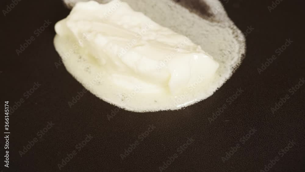 The butter slowly melts in a hot metal skillet. Cooking food in the home kitchen. The butter slowly melts in a hot metal skillet. Cooking food in the home kitchen.